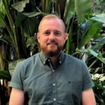 Female psychologist making notes with pleasure smile while holding video call