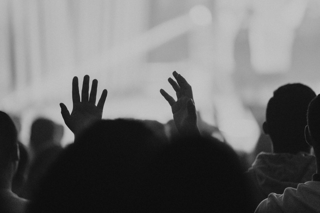Worshippers raising their hands during a contemporary Christian worship gathering.